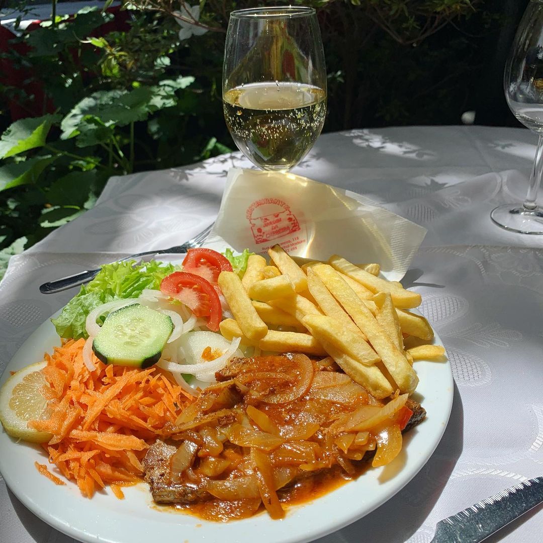 Restauracja Jardim da Carreira w Funchal, danie dnia stek z tuńczyka z cebulą. Każdego dnia można wybrać jedzenie na jakie ma się ochotę jako danie dnia. Cena jedyne 5,50 e. Lampka białego chłodnego wina wskazana wśród promieni słonecznych ogrodu.Zapraszam